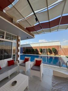 a patio with chairs and a swimming pool at Masa villa in Ash Shāghūr