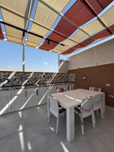 a table and chairs in a room with a large window at Masa villa in Ash Shāghūr