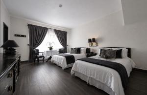 a hotel room with two beds and a table at Hotel Royal Spa in Zimapán