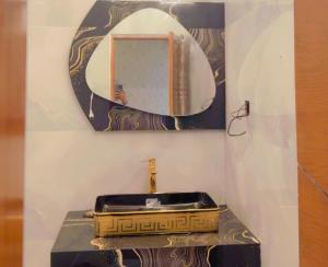 a bathroom with a sink and a mirror at Sapphire Guest House in Karachi +3 photos