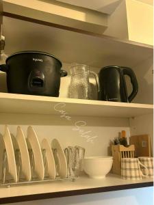 a kitchen shelf with plates and utensils on it at Aurora Escalades in Manila +6 photos