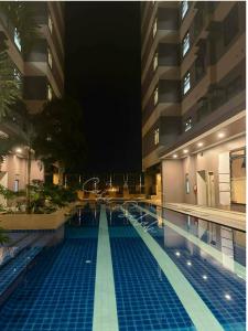 a large swimming pool in a hotel at night at Aurora Escalades in Manila