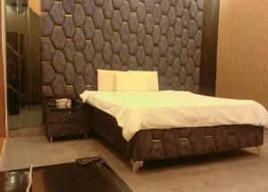 a bedroom with a bed with a padded wall at Sapphire Guest House in Karachi
