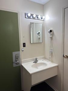 a bathroom with a sink and a mirror at Auberge Eldo Inn in Blind River