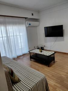 a living room with a couch and a flat screen tv at Danny ap - Amplio y cómodo - 18 min Aeropuerto - Zona de Restos - Parking in Monte Grande