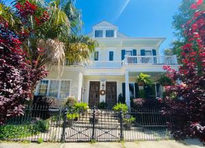 a white house with a fence in front of it at The Dragonfly Tremé-Historic Guesthouse-Near French Quarter in New Orleans