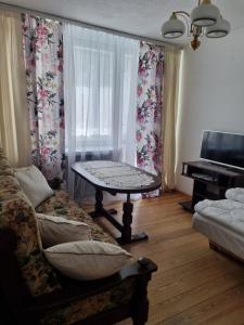 a living room with a couch and a table and a piano at Apartament Centrum Zgorzelec in Zgorzelec