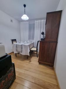 a dining room with a white table and a wooden floor at Apartament Centrum Zgorzelec in Zgorzelec