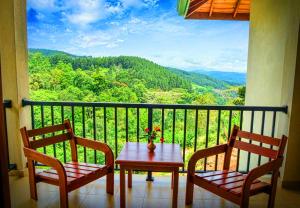 a table and two chairs on a balcony with a view at Grand Hills in Kandy