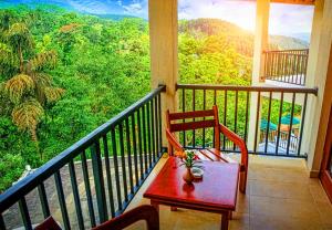 a balcony with a red chair and a view at Grand Hills in Kandy