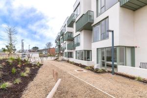 an apartment building with a dirt road in front of it at Apex Executive Apartments - The Lookout in Dublin