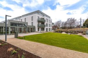 a large white building with a park in front of it at Apex Executive Apartments - The Lookout in Dublin