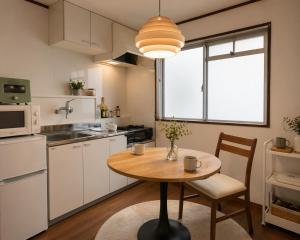 a small kitchen with a wooden table and a dining room at 徳島駅徒歩10分 公園前 Netflix DiDi Base 203 in Tokushima