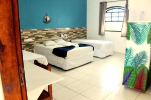 a room with two beds and a couch in it at Beija Flor Pousada in Ubatuba