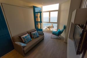 a living room with a couch and a large window at Virginia's Dream Panoramic Sea View Loft in Las Palmas de Gran Canaria