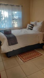 a bedroom with a large bed with a window at Hyponia 1512 in Oshikuku