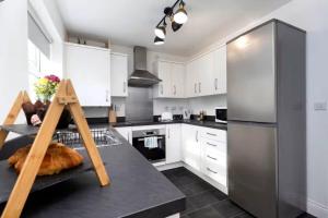 a kitchen with white cabinets and a black counter top at DiscountsContractorsWIFIFree ParkingSmart TV in Gateshead