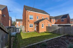 a brick house with a fence in a yard at DiscountsContractorsWIFIFree ParkingSmart TV in Gateshead