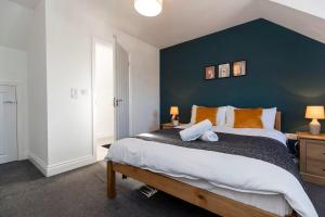 a bedroom with a large bed with a blue wall at DiscountsContractorsWIFIFree ParkingSmart TV in Gateshead
