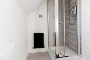 a shower stall with a speaker in a bathroom at DiscountsContractorsWIFIFree ParkingSmart TV in Gateshead +20 photos