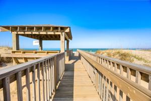 a wooden boardwalk to the beach with a shelter at QCB5 - Saltaire Sunrise in Nags Head
