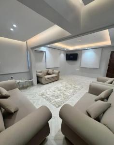 a living room with couches and a flat screen tv at Sultana Apartments in Abha