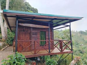 a small wooden building with a roof on a hill at Cielo nocturno Perez Zeledon in Berlín +7 photos