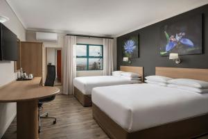 a hotel room with two beds and a desk at Protea Hotel by Marriott Cape Town Tyger Valley in Bellville +25 photos