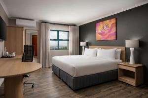 a hotel room with a bed and a desk at Protea Hotel by Marriott Cape Town Tyger Valley in Bellville
