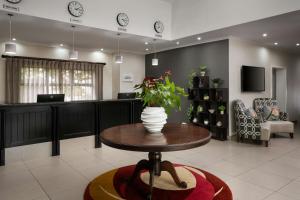 a lobby with a table with a vase of flowers on it at Protea Hotel by Marriott Cape Town Tyger Valley in Bellville