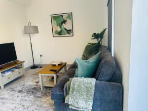 a living room with a blue couch and a table at Ridgeways Premium House in Bristol