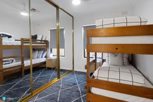 a room with two bunk beds and a mirror at Beachside Largs Bay Pet Friendly 3 Bed Haven in Birkenhead