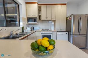 a kitchen with a bowl of fruit on a counter at Beachside Largs Bay Pet Friendly 3 Bed Haven in Birkenhead +28 photos