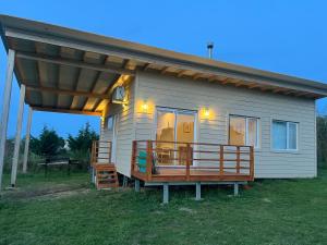 a small house with a porch and a deck at Cabaña Flor Tandil in Tandil