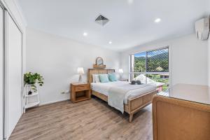 a bedroom with a bed and a window at Blue Lagoon Airlie Beach in Airlie Beach