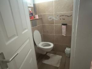a small bathroom with a toilet with the lid up at La maison de la plage in Sainte-Luce
