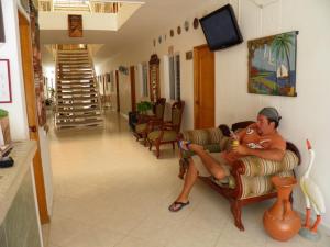 a man sitting on a couch holding a baby at Blanco Mar Hotel in Santa Marta