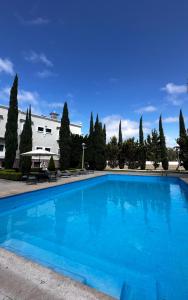 a large blue swimming pool in front of a building at Hotel Royal Spa in Zimapán