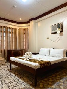 a bedroom with a bed and a tv on the wall at Sequor Palm Villa in Siquijor