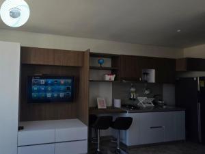 a kitchen with a counter and two stools in it at Apartamento en el Rodadero, a pocos metros de la playa in Gaira +18 photos