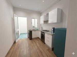 a kitchen with white cabinets and a blue refrigerator at S plus 1 in Nabeul