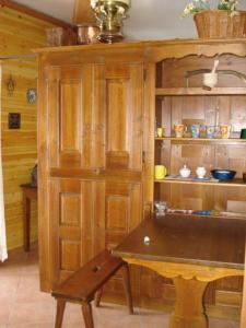 a kitchen with a table and a wooden cabinet at Appartamento Bianco in Borgata Sestriere