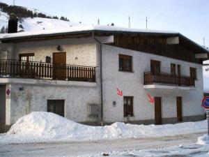 a building with a pile of snow in front of it at Appartamento Bianco in Borgata Sestriere