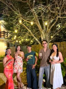 a group of people posing for a picture in front of a tree at Sequor Palm Villa in Siquijor +69 photos