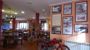 un restaurant avec un vélo sur un mur orné de photos dans l'établissement Convento de Foncebadon, à Foncebadón