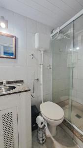 a bathroom with a shower and a toilet and a sink at Aura House Búzios in Búzios