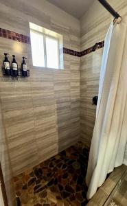 a bathroom with a shower and a window at The Bungalow @Terra Monarca in El Porvenir