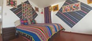 a bedroom with a bed with a colorful blanket at Uros & Titicaca Sunset Comfort Floating cabins in Puno
