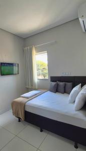a bedroom with a large bed with a window at AP Completo Próx Centro, Hospitais, Dist Industrial in Montes Claros +38 photos
