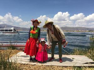 a man and two women and a little girl on a dock at Uros & Titicaca Sunset Comfort Floating cabins in Puno +5 photos